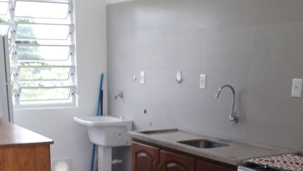 A kitchen with a wooden table, a sink, cabinets, and a stove. - 04 - Holiday apartment - Morada Madruga (Praia do Sonho (Ens Brito))