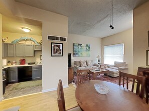 A spacious living room with a dining area, a kitchen in the background, and a large window providing natural light. - Amazon Alexa enabled apartment one Block from Lafayette Park (St. Louis)