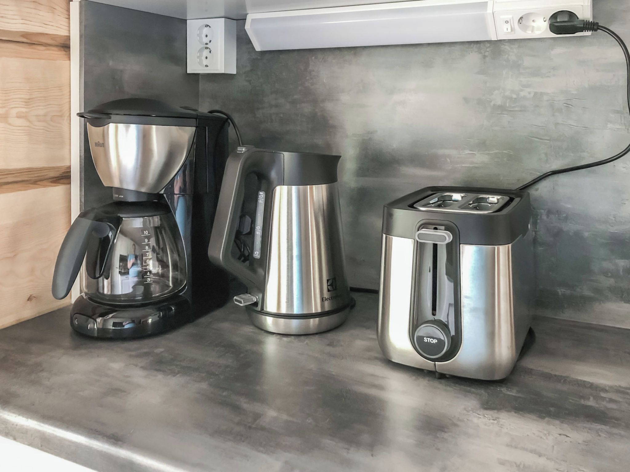 En køkkenbordplade med kaffemaskine, elkedel og brødrister.