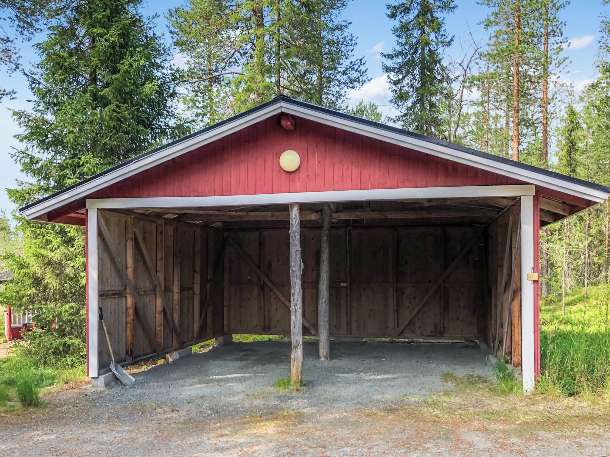 A red barn with a gabled roof and a single light fixture.