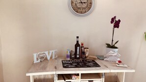 Un bureau en bois avec une horloge, des bouteilles, une plante en pot et un panneau portant le mot « Amour ».