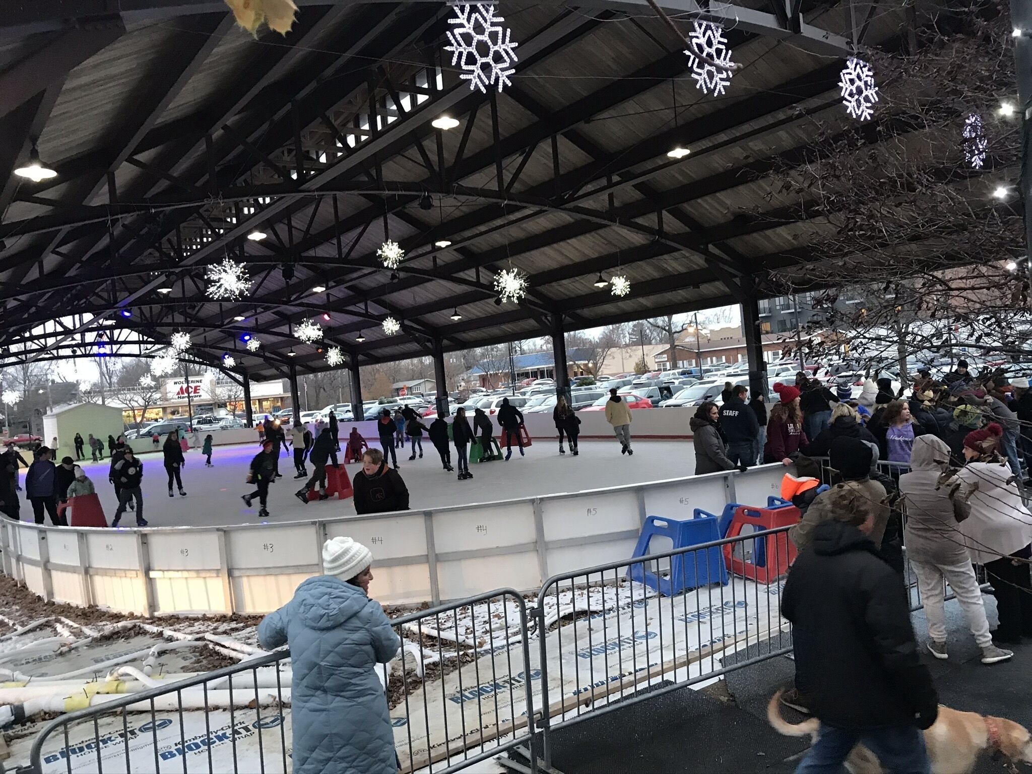 Eine Eislaufbahn im Freien mit überdachtem Dach und Schneeflocken-Dekoration.