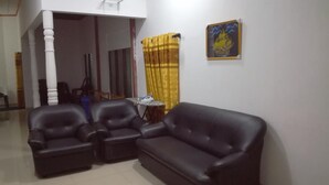A living room with a sofa and two armchairs, a small table, and a yellow curtain. - Hotel  Jonkoping (Godakawela)