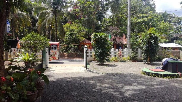 A courtyard with a small kiosk, a white fence, and various plants. - Hotel  Jonkoping (Godakawela)