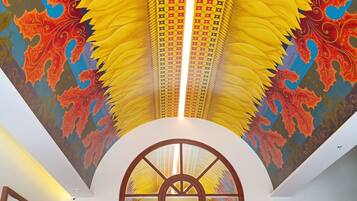 A ceiling with a vibrant, geometric pattern and an arched window.