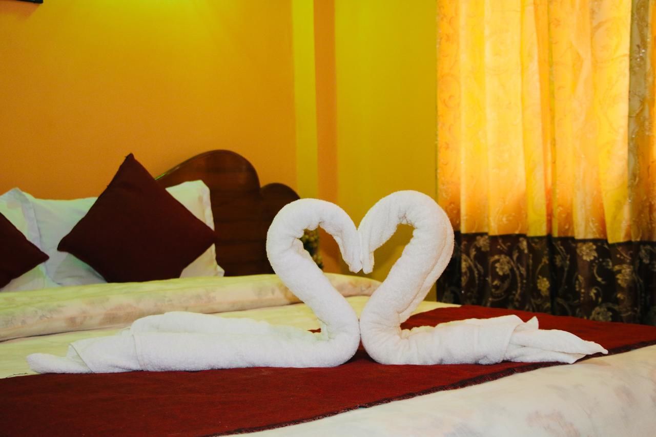 Una cama con una toalla en forma de corazón y una manta roja.