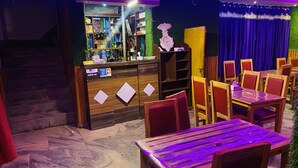 A bar area with wooden furniture and a reception desk. - Taplejung Hotel Pathivara (Taplejung)