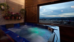A hot tub area with a view of mountains and a wooden interior. - Monopoly Pension (Gyeongju)