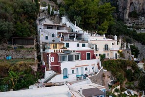 A hillside building with multiple levels, balconies, and a mix of architectural styles. - Il Sogno Costa d’Amalfi - Sea View Apartment (Conca dei Marini)