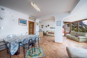 A spacious living area with a dining table, chairs, and a sofa. - Il Sogno Costa d’Amalfi - Sea View Apartment (Conca dei Marini)