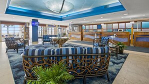 A lobby with a central seating area, a reception desk, and a large window. - Bay Watch Resort 419 - Beautiful North Myrtle Beach Oceanfront 1 Bedroom 1 Bath (North Myrtle Beach)