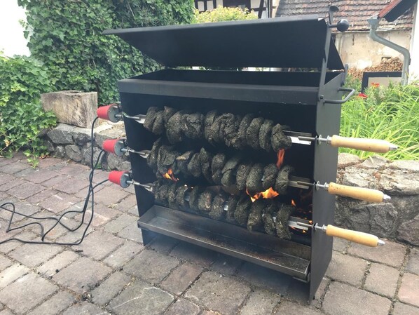 Een kolengrill met meerdere spiesen eten die buiten worden bereid.