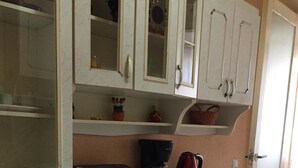 Eine Küche mit weißen Schränken, einer Kaffeemaschine und einem Toaster.