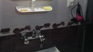 Ein Badezimmer mit Waschbecken, Spiegel und Duschbereich.