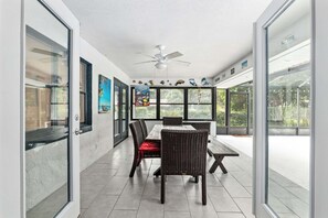 An open-plan dining area with a ceiling fan, large windows, and a view of the outdoors. - Vacation Home With A Stunning View - 870 3 Bedroom Home by RedAwning (Inverness)