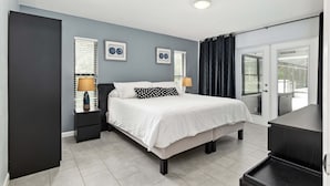 A modern bedroom with a bed, two bedside tables, a window with blinds, and a view of the outside. - Vacation Home With A Stunning View - 870 3 Bedroom Home by RedAwning (Inverness)