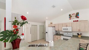 A kitchen with a central island, white cabinets, a microwave, and a stove. - Family Villa Bettina - Recently Remodeled 2 Bedroom Home by RedAwning (Inverness)