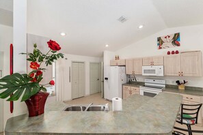 A kitchen with a central island, white cabinets, a microwave, and a stove. - Family Villa Bettina - Recently Remodeled 2 Bedroom Home by RedAwning (Inverness)
