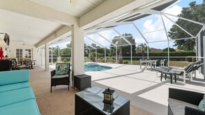 A covered outdoor area with a pool, lounge chairs, and a dining table. - Family Villa Bettina - Recently Remodeled 2 Bedroom Home by RedAwning (Inverness)