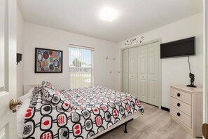 A bedroom with a bed, a television, a wardrobe, and a painting on the wall. - Family Villa Bettina - Recently Remodeled 2 Bedroom Home by RedAwning (Inverness)
