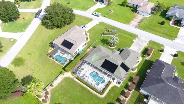 An aerial view of a residential area with two houses, each featuring a swimming pool and solar panels. - Family Villa Bettina - Recently Remodeled 2 Bedroom Home by RedAwning (Inverness)
