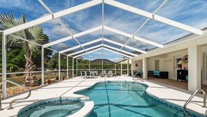 A covered outdoor swimming pool with two hot tubs, surrounded by lounge chairs and a patio area. - Family Villa Bettina - Recently Remodeled 2 Bedroom Home by RedAwning (Inverness)