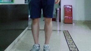 A person standing in a room with a kitchen area, a framed picture on the wall, and a patterned rug on the floor. - Cozi Hotel (Hai Phong)