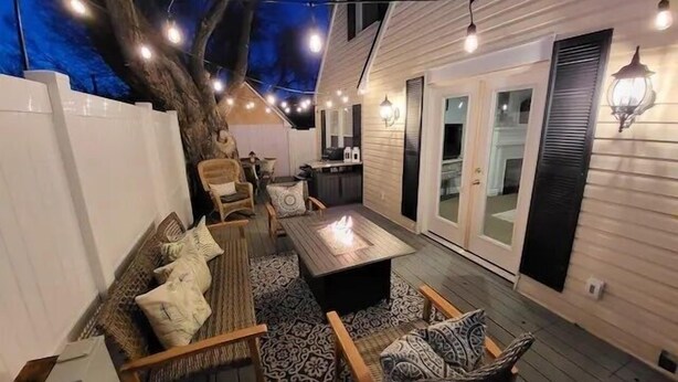 A cozy outdoor seating area with a fire pit, string lights, and a large tree. - Film-featured, sleeps 18, hot tub, fire pit, decks (Heber City)