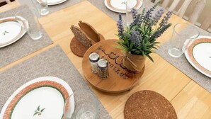 A dining table set with plates, glasses, and a centerpiece with a plant and salt shakers. - Film-featured, sleeps 18, hot tub, fire pit, decks (Heber City)