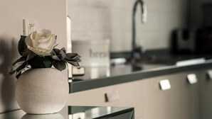 A modern kitchen with a white vase containing a white rose on the counter. - Sunset Penthouse Apartment with Hot Tub (Zadar)