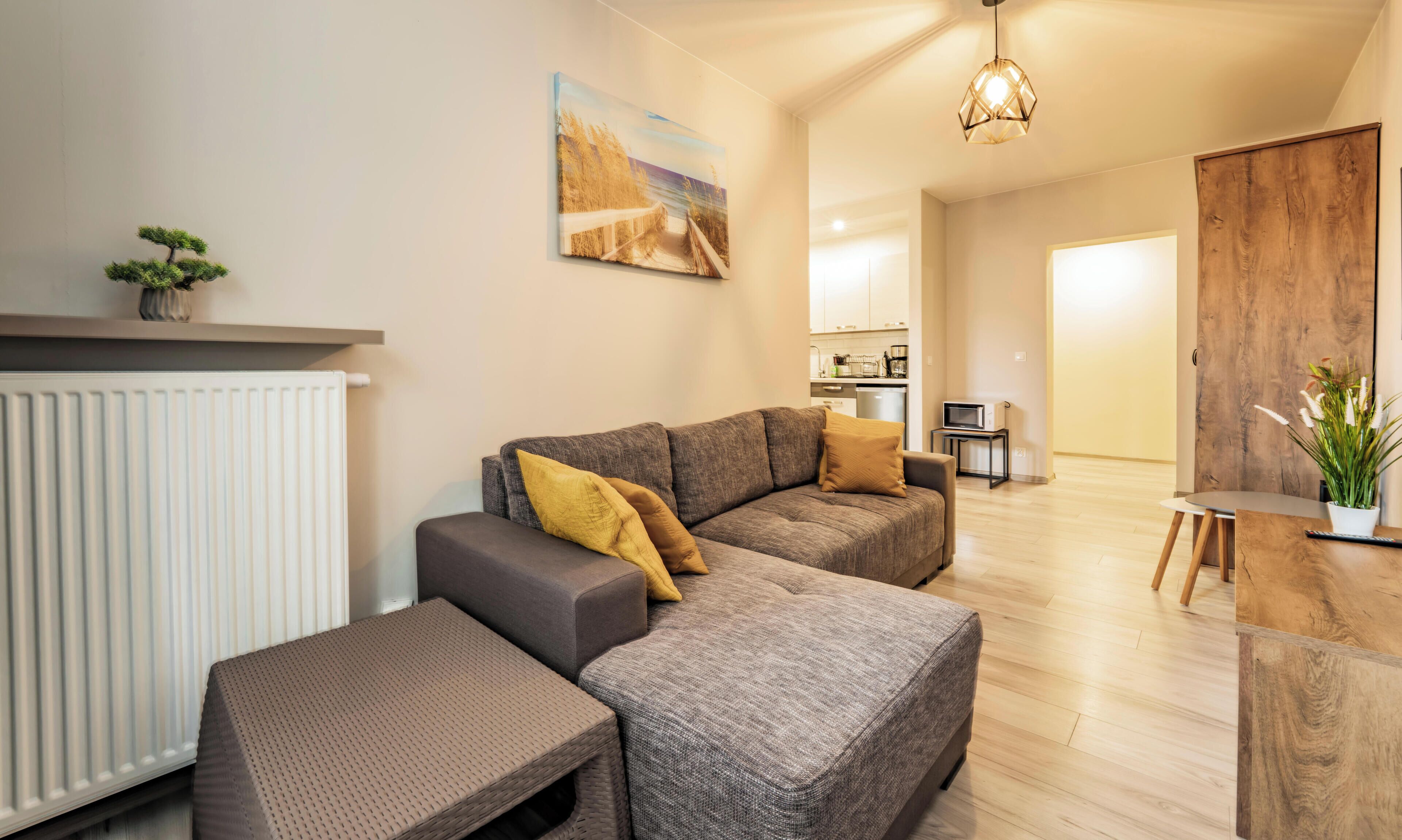 A modern living room with a sectional sofa, a small table, and a potted plant.