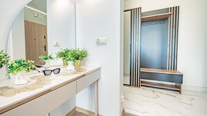 A modern bathroom with a vanity, mirror, potted plants, and a wooden bench. - Baltic Apartments - Apartamenty Bałtyk (Swinoujscie)