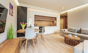 Un appartement moderne comprenant une cuisine, un coin repas et un salon.