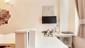 A modern kitchen with a gas stove, a coffee maker, and a small shelf with kitchen items. - Cosy Nest Isola District Heart (Milan)