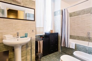 Bathroom features a pedestal sink, shower area, and storage cabinet.