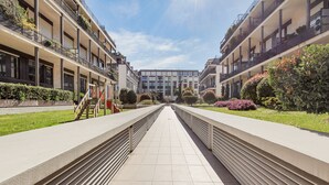 A modern building with a central courtyard, featuring a symmetrical design with balconies and greenery. - Elegant Loft with balcony (Milan)