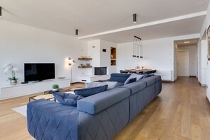 Apartamento superluxo, 2 quartos, banheira de imersão, vista para o mar | Área de estar | TV de tela plana, lareira, pisos aquecidos