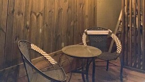 A wooden interior with two wicker chairs and a small round table. - Hago Guest House (Tongyeong)