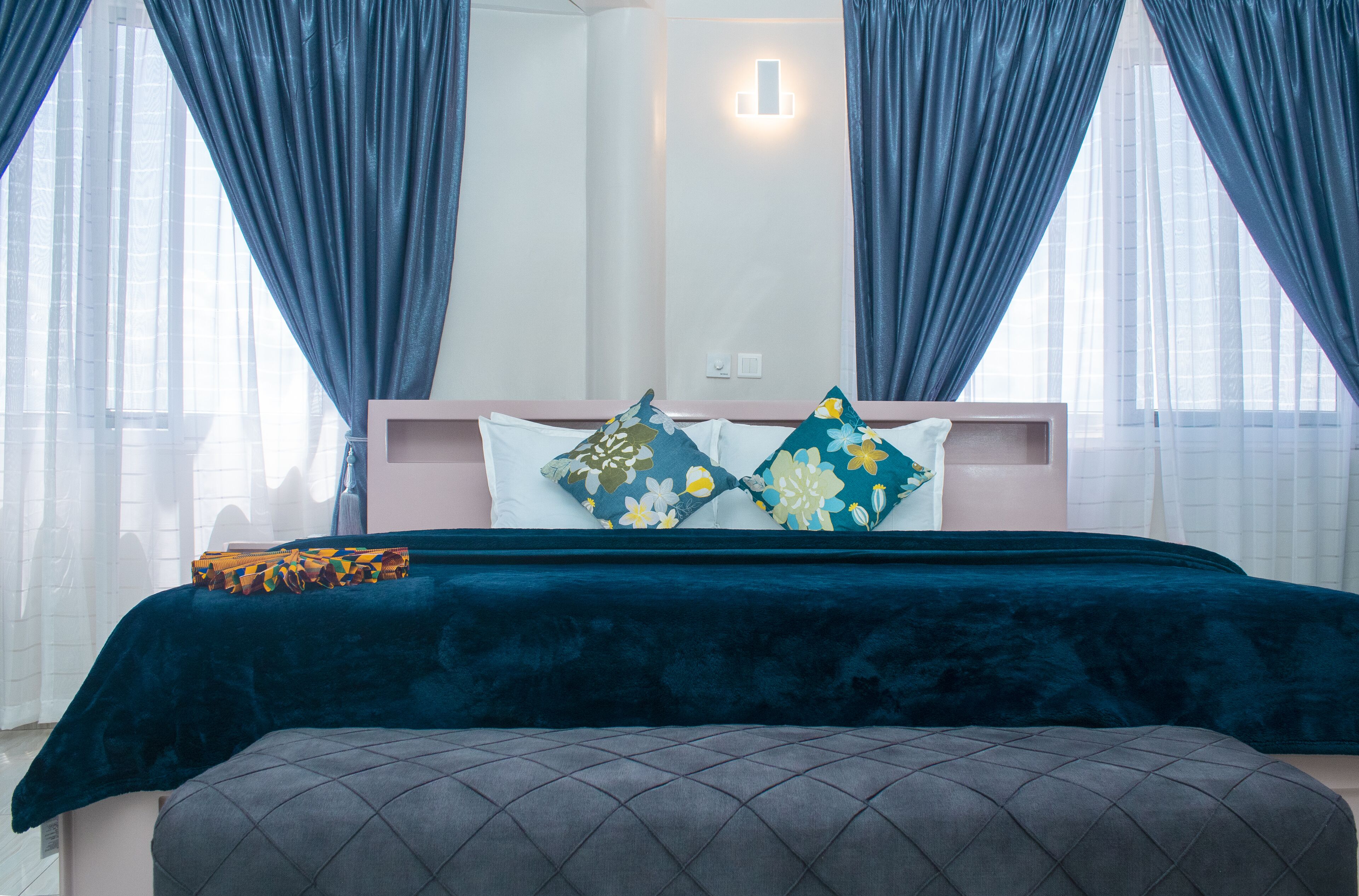A bedroom with a bed, a nightstand, and a bench.