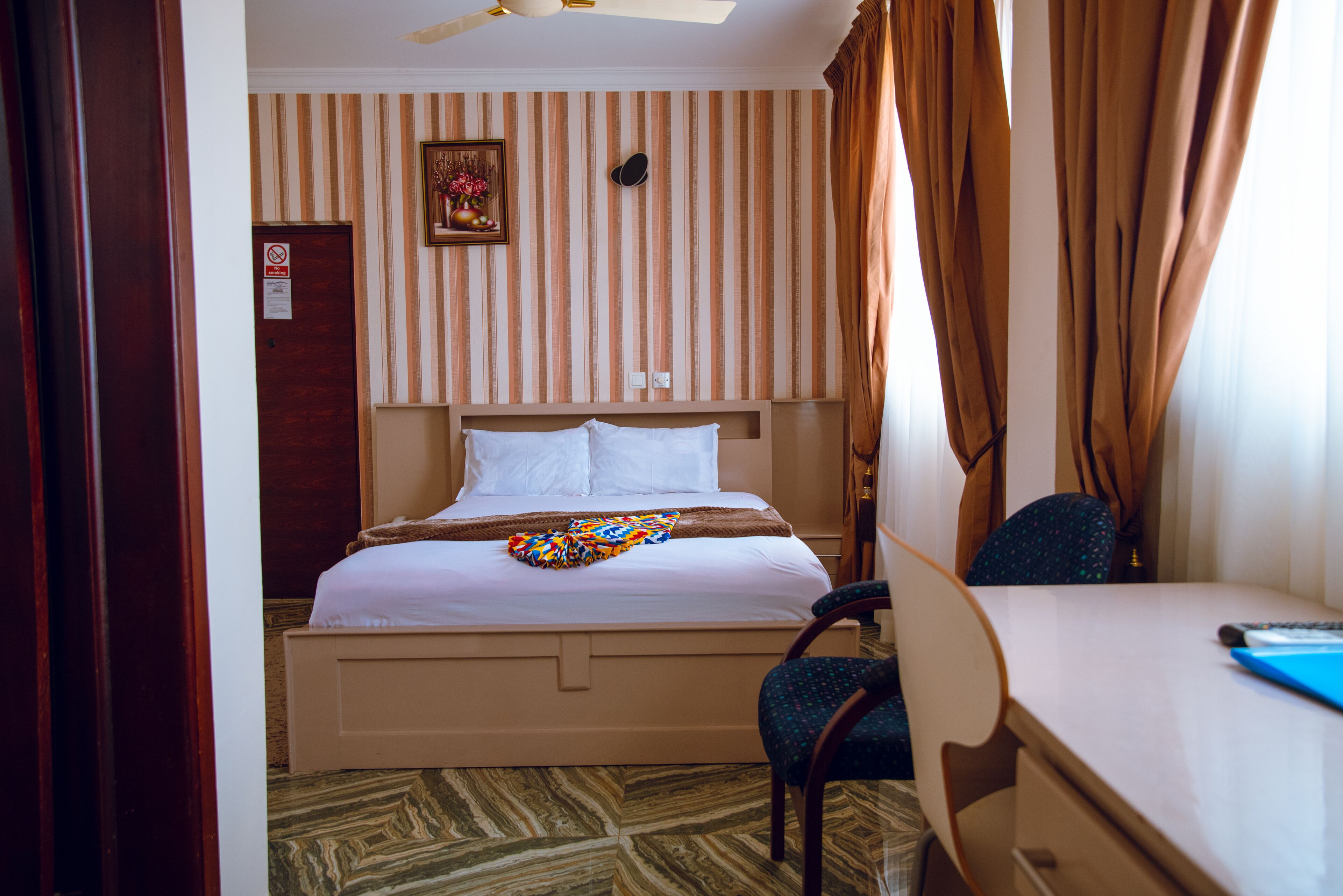 A hotel room with a bed, a desk, and a chair.
