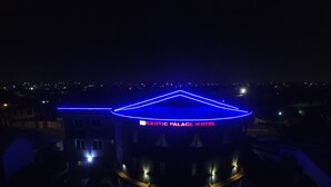 The exterior of Exotic Palace Hotel with a distinctive blue neon sign and a modern architectural design. - Exotic Palace Hotel (Accra)