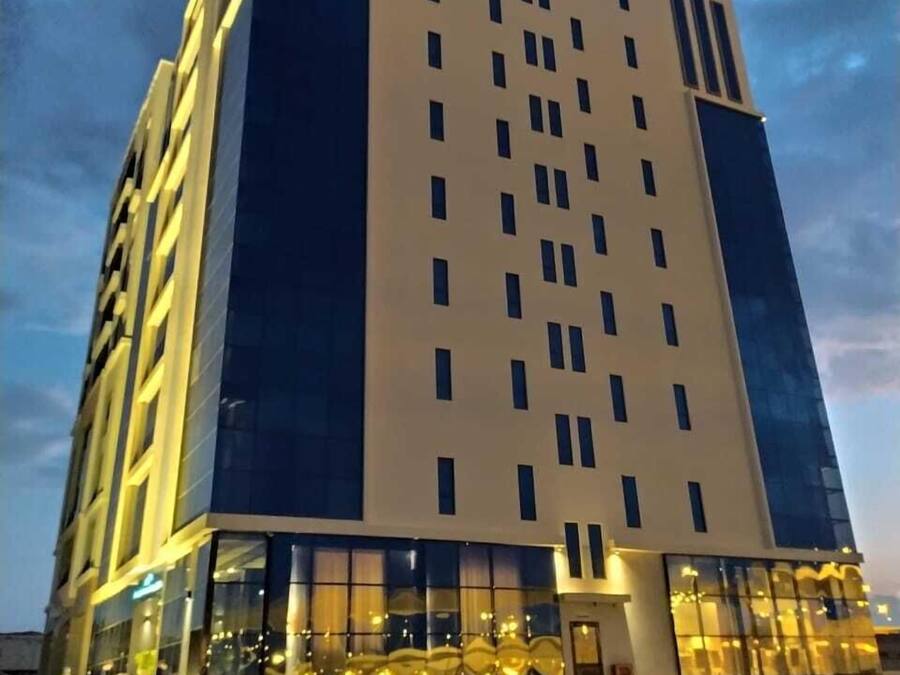 Ein mehrstöckiges Hotel mit moderner Fassade, großen Fenstern und einer auffälligen Beschilderung oben.