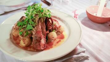 A plate of food with meat, potatoes, and greens on a white plate.