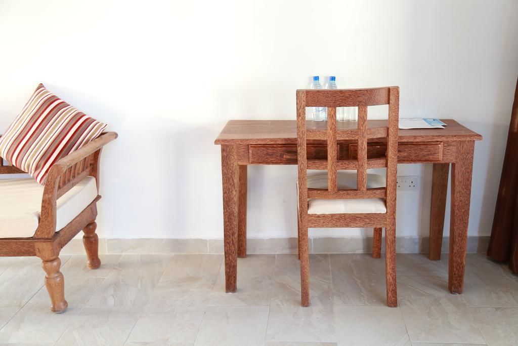 Een houten stoel en tafel in een kamer met een betegelde vloer.