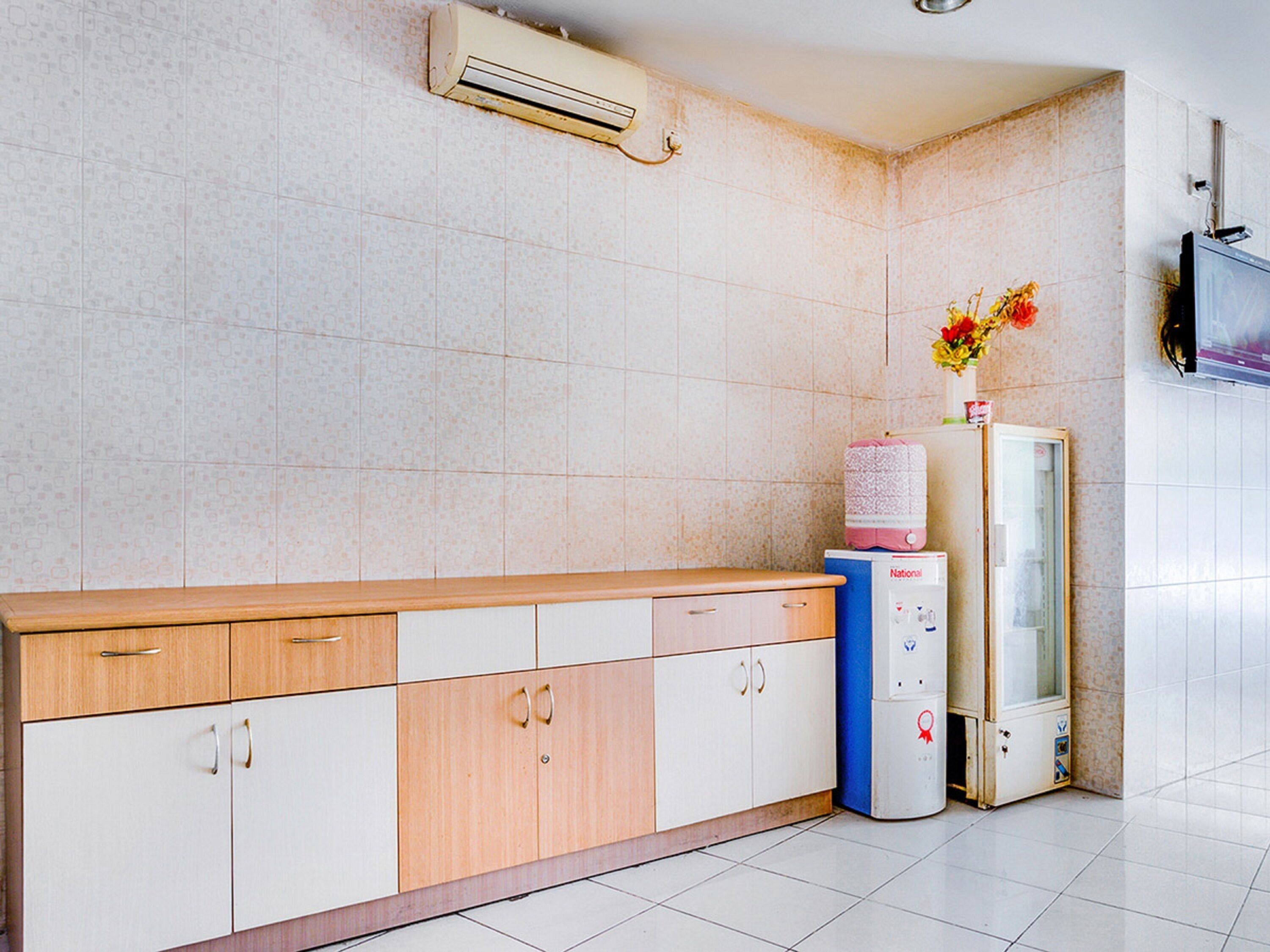 A clean, modern kitchen with a wooden countertop, white cabinets, and a built-in water dispenser.