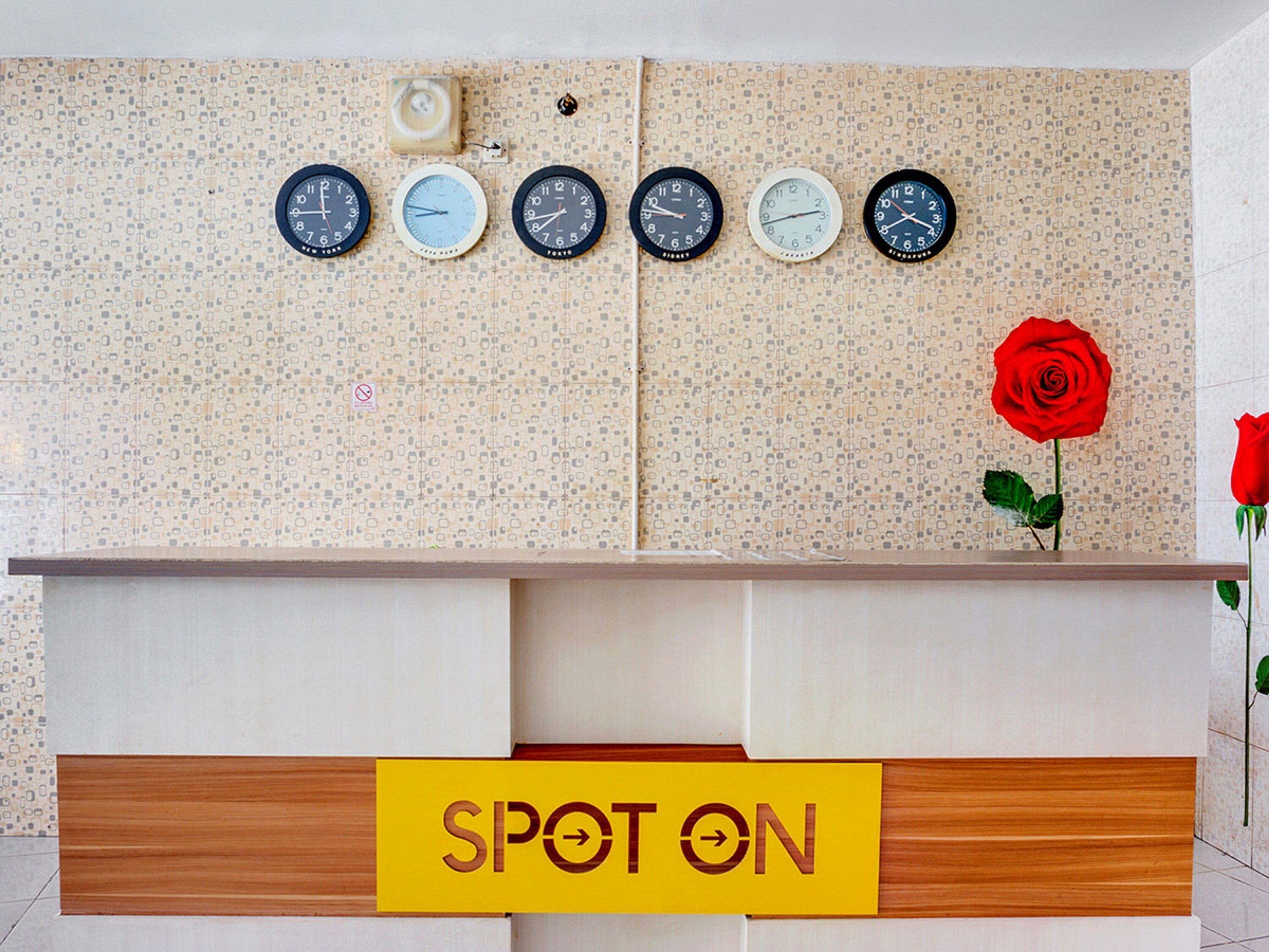 Ein Empfangstresen mit mehreren Uhren und einem Schild mit der Aufschrift 'SPOT ON'.