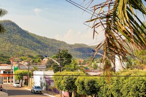 A street view with buildings, a car, and a hill in the background.
