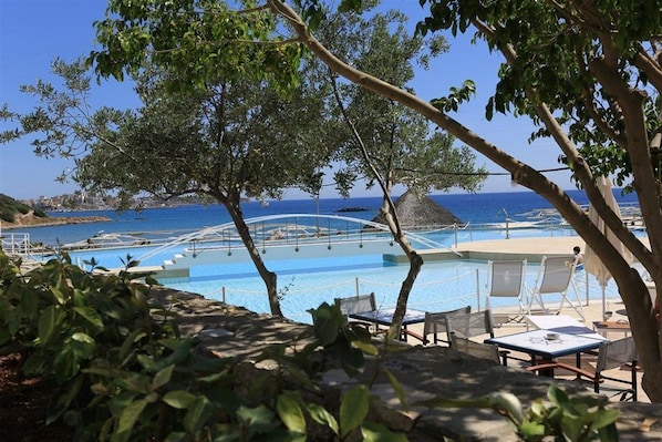 A pool area with lounge chairs and a view of the sea. - Blu Acqua (Agios Nikolaos)