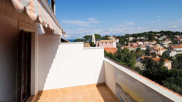En balkon med udsigt over en by, med en bygning med flisegulv og en dør.