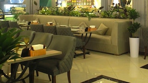 A spacious lobby with a seating area, a bar, and a chandelier. - Simma Hotel spa and waterpark (Tashkent)